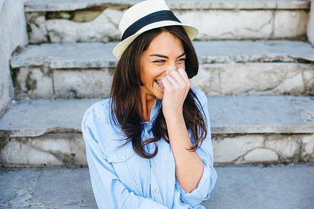 Beautiful female fashion model sitting and laughing.
