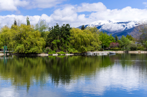 puigcerdà lake with green tree and snow capped mountains