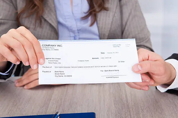 Photo of Businesspeople Holding Cheque