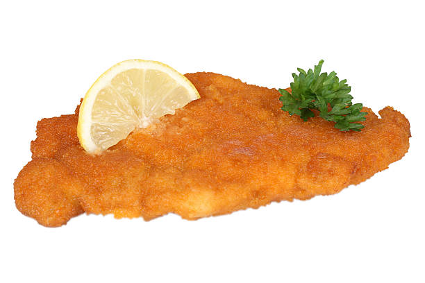 Schnitzel chop cutlet with lemon and parsley isolated Schnitzel chop cutlet with lemon and parsley isolated on a white background breaded photos stock pictures, royalty-free photos & images
