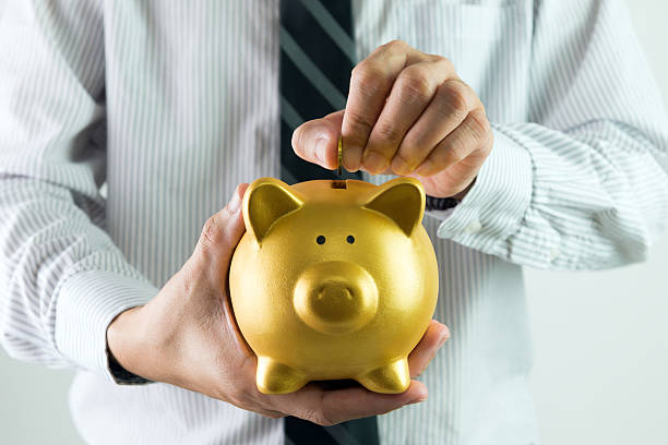 istock Putting coin into piggy bank 465696508