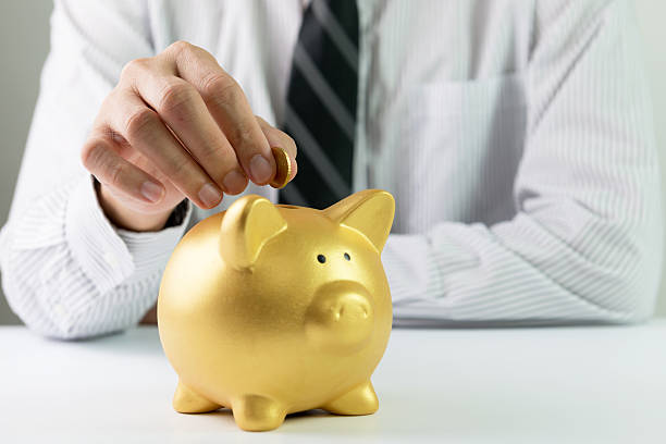 istock Putting coin into piggy bank 465696510