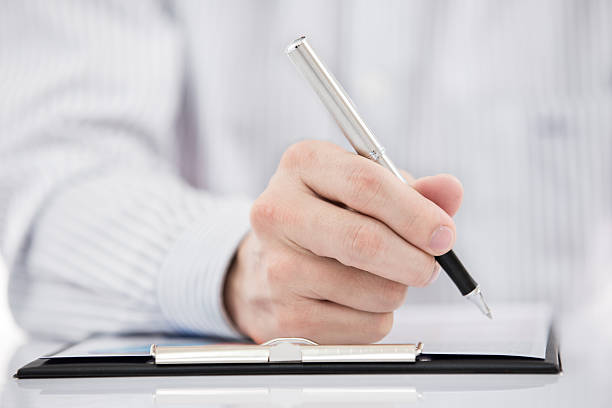 istock man hand with pen and business report 465697237