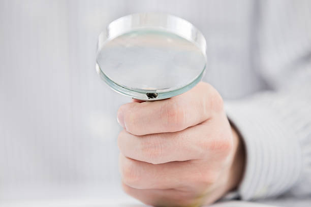 istock Businessman looking through a magnifying glass 465697247