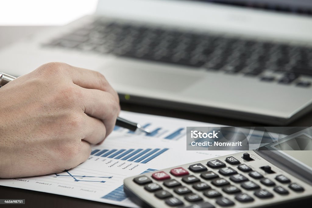 Businessman analyzing investment charts Businessman analyzing investment charts with laptop Adult Stock Photo