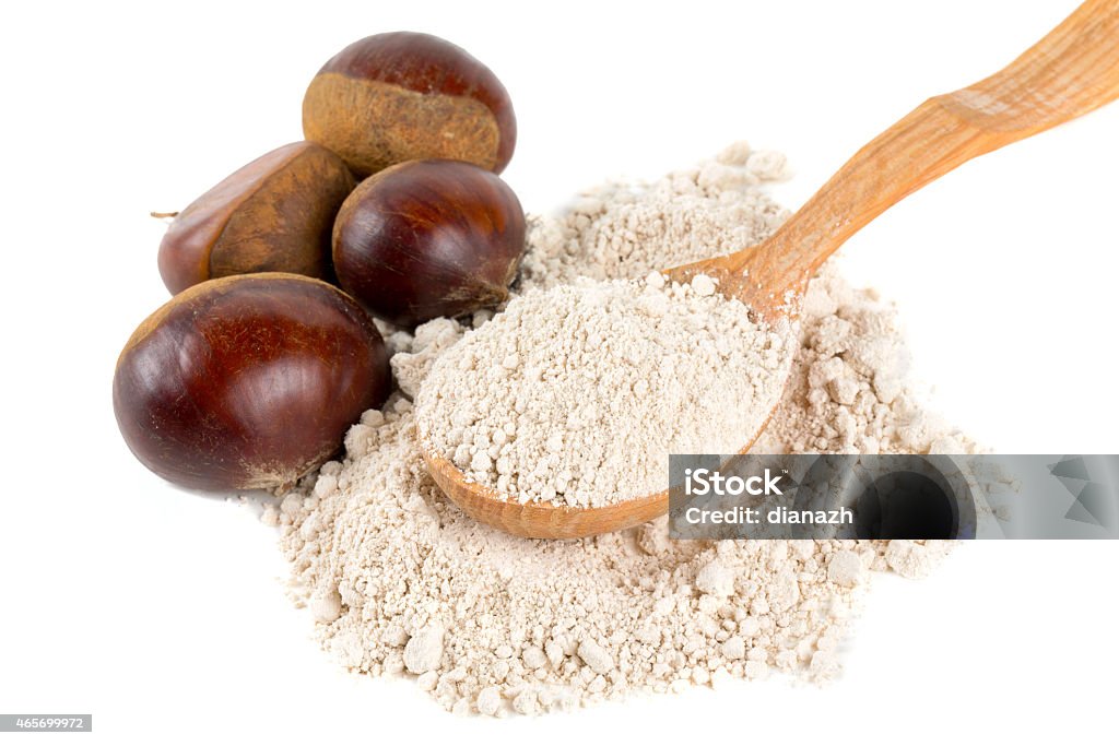 chestnut flour in a wooden spoon isolated on white Chestnut - Food Stock Photo