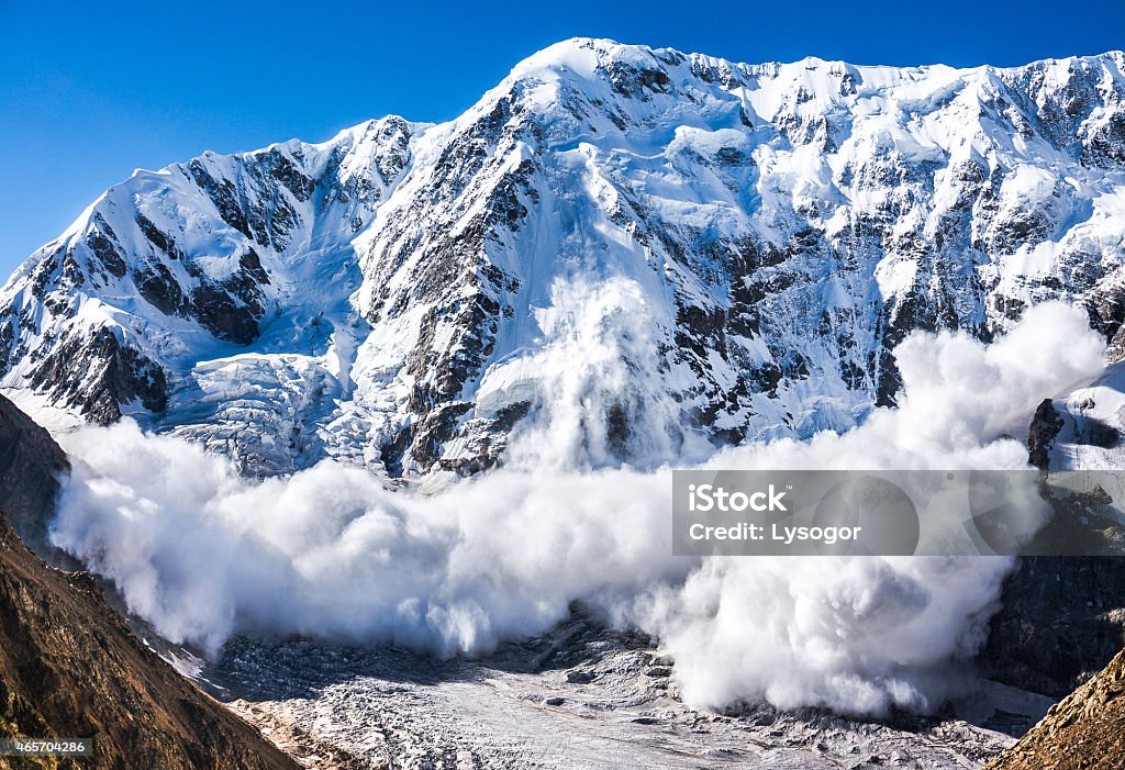 Large avalanche coming down the rocky Caucasus mountain Real huge avalanche comes from a big mountain (Shkhara, 5,193 m), Caucasus, Kabardino-Balkaria, Bezengi region, Russia Avalanche Stock Photo