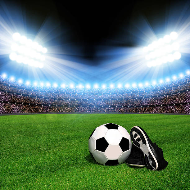 istock Soccer ball and shoes in grass 465706904