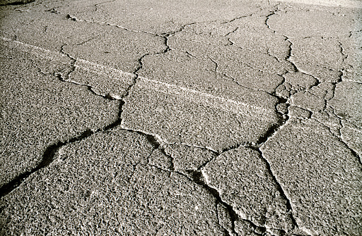 a black and white photograph of cracked pavement.