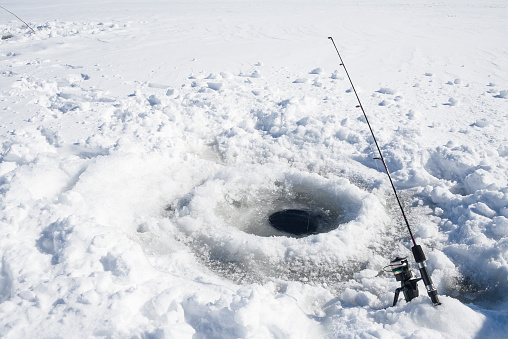 Ice fishing hole on a frozen lake in Ontario, Canada.