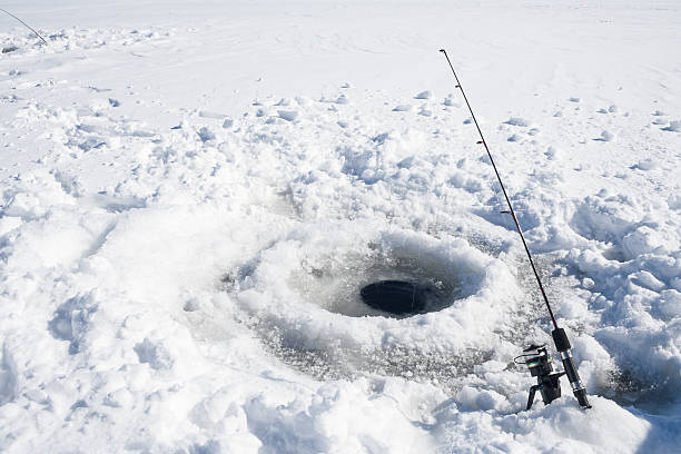 Ice Fishing Hole Ice fishing hole on a frozen lake in Ontario, Canada. ice fishing stock pictures, royalty-free photos & images