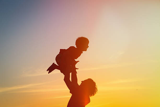 istock father and son silhouettes play at sunset 465719540