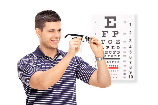istock Man wiping his glasses in front of an eye chart 465722016