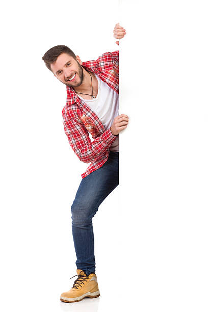 istock Smiling man jumping out from behind white banner 465724788