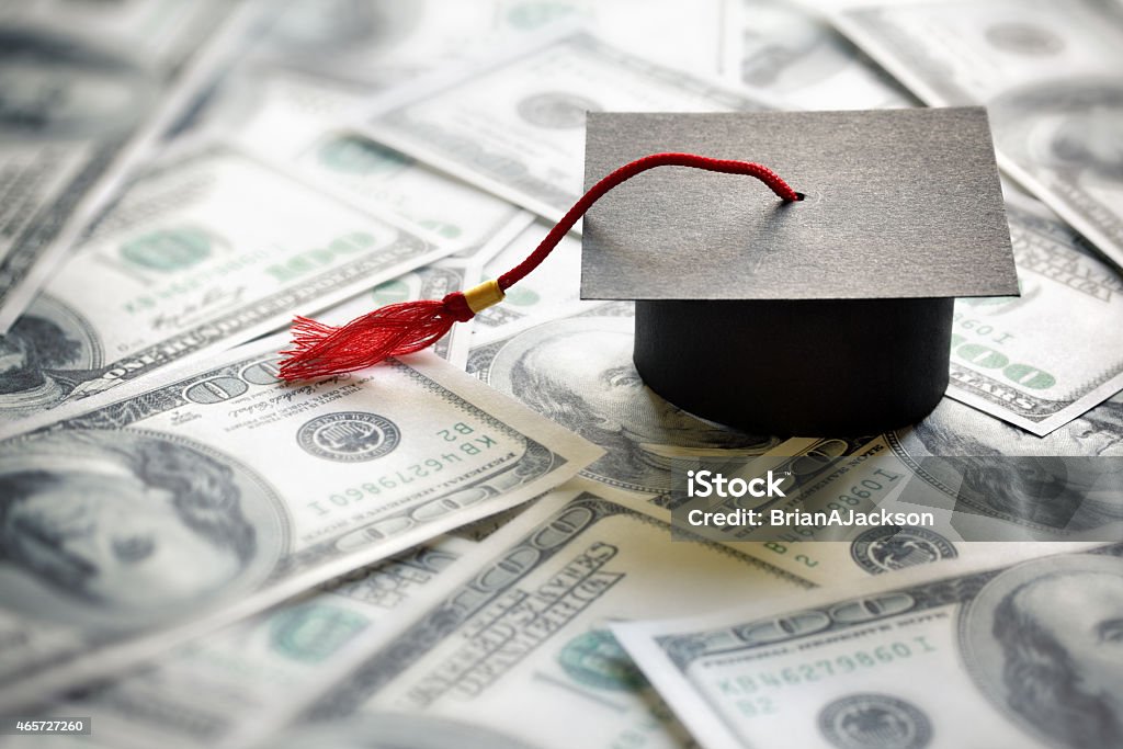 Saving for education Graduation mortar board cap on one hundred dollar bills concept for the cost of a college and university education Student Loan Stock Photo