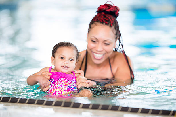istock Mother and daughter in swimming pool 465738716