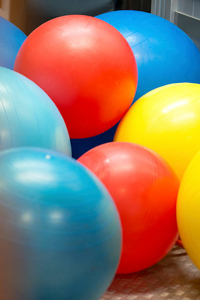 Red, blue, yellow exercise balls in the school gymnasium, Europe. Nikon D800, full frame, XXXL. Soft focus.