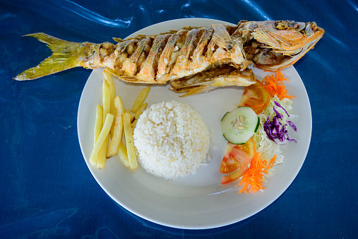 Whole fried fish served with rice, salad and frech fries.  Typical central American meal.