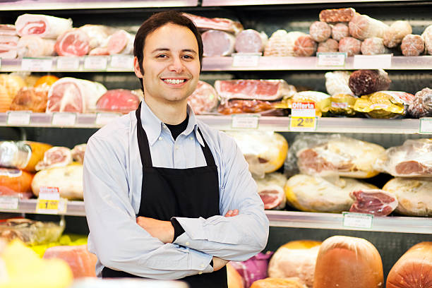 istock Smiling shopkeeper posing in front of meat 465746862