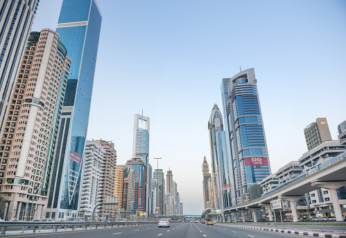Dubai, United Arab Emirates - February 27, 2015: Driving down the busy Sheikh Zayed Road at sunset which is surrounded by office buildings and the Metro on the right. The road has six lanes in both directions.