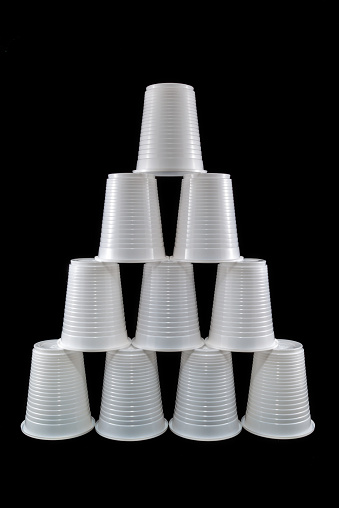 Pyramid made of plastic cups isolated on black