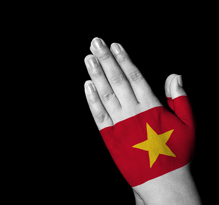 Hands folded in prayer - VietNam flag painted on hands - Digitally generated