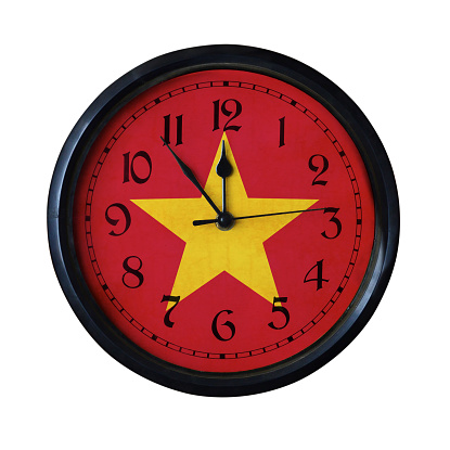 An old VietNam flag wall clock with grungy background - isolated over white.