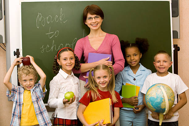 istock Teacher with her students in front of a blackboard 465757224