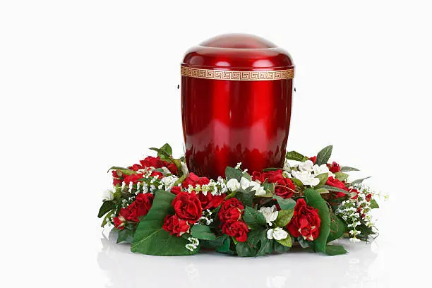 Red urn and floral wreath on white background