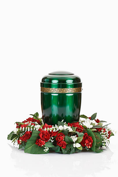 istock Green urn and floral wreath on white background 465762378