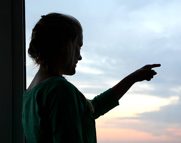 istock Germany, Berlin, young woman looking out of window 465763076