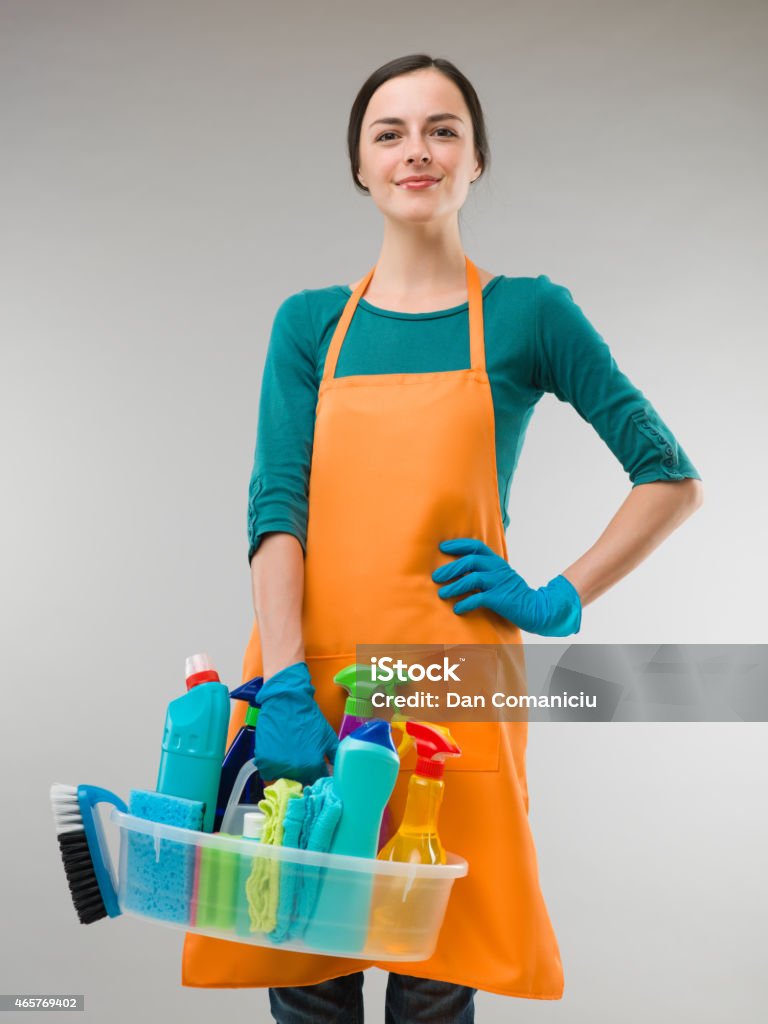 happy cleaner happy woman holding cleaning equipment and looking in front of the camera, on grey background 2015 Stock Photo