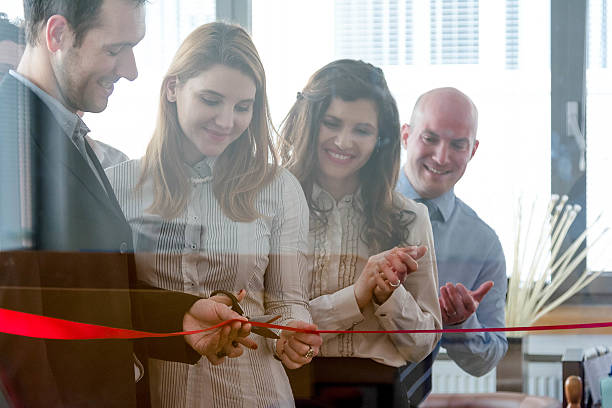 Opening of new office space Medium group of people is applauding for new business venture. ceremony photos stock pictures, royalty-free photos & images