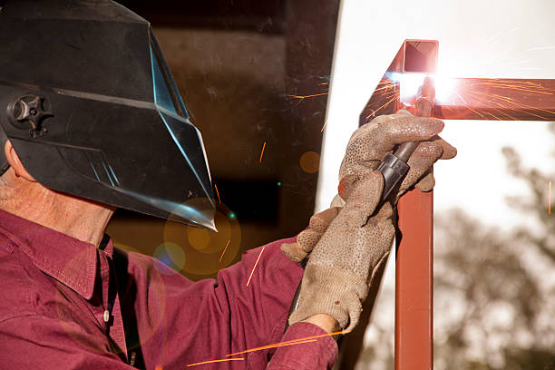 istock Man welding. Welder's helmet. Len's flare. Blue collar worker. 465777848