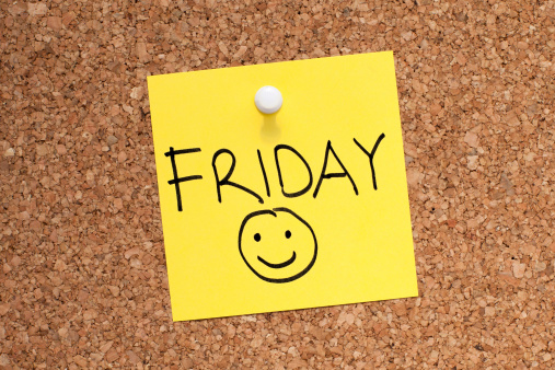 FRIDAY note with smiley face pinned on cork noticeboard