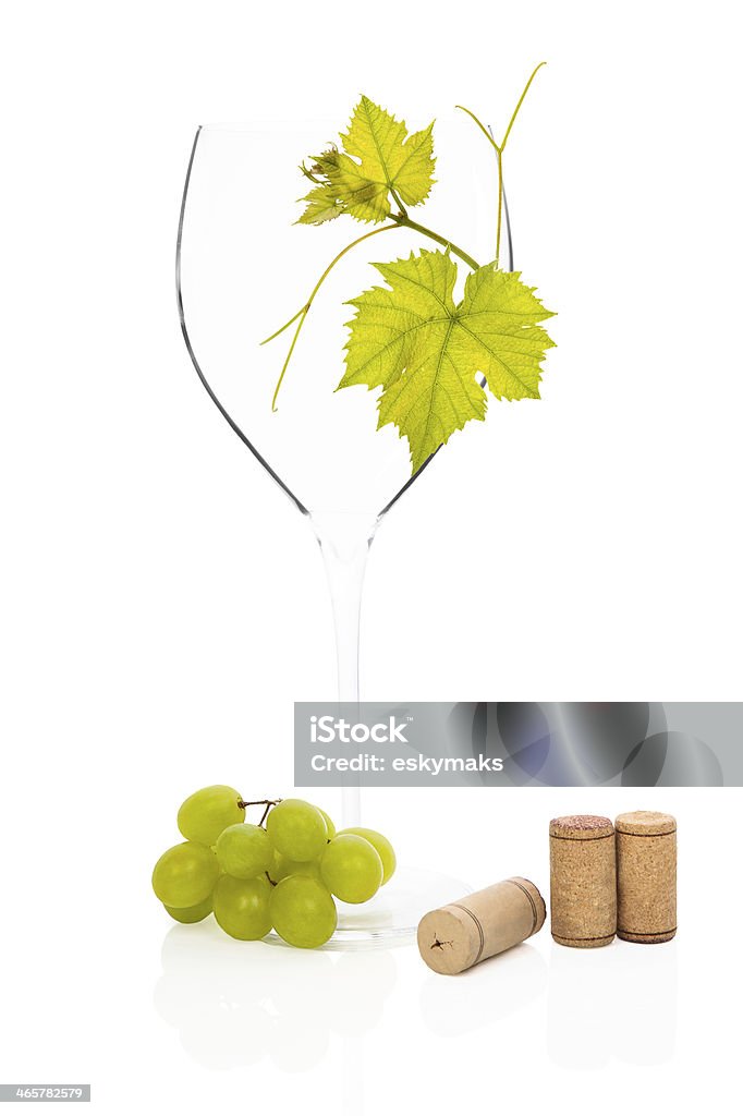 Empty goblet. Luxurious empty wineglass with vine leaves, green grapes and wine corks isolated on white background. Luxurious culinary wine drinking still life. Alcohol - Drink Stock Photo