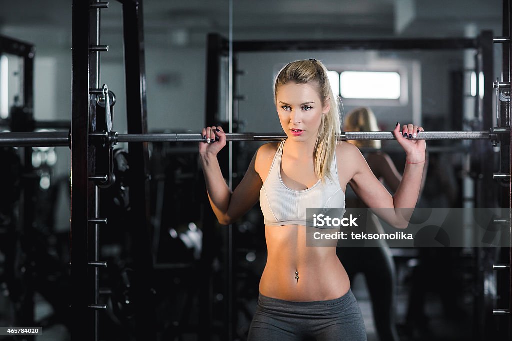 Girl doing exercise with barbell in gym girl in great shape in the gym Rebar Stock Photo