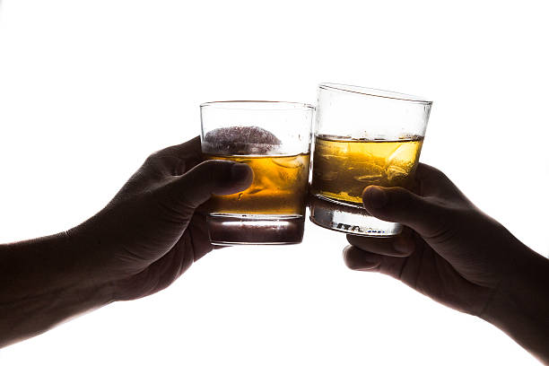 duas mãos em silhueta brindando whiskey no rock - scotch on the rock - fotografias e filmes do acervo