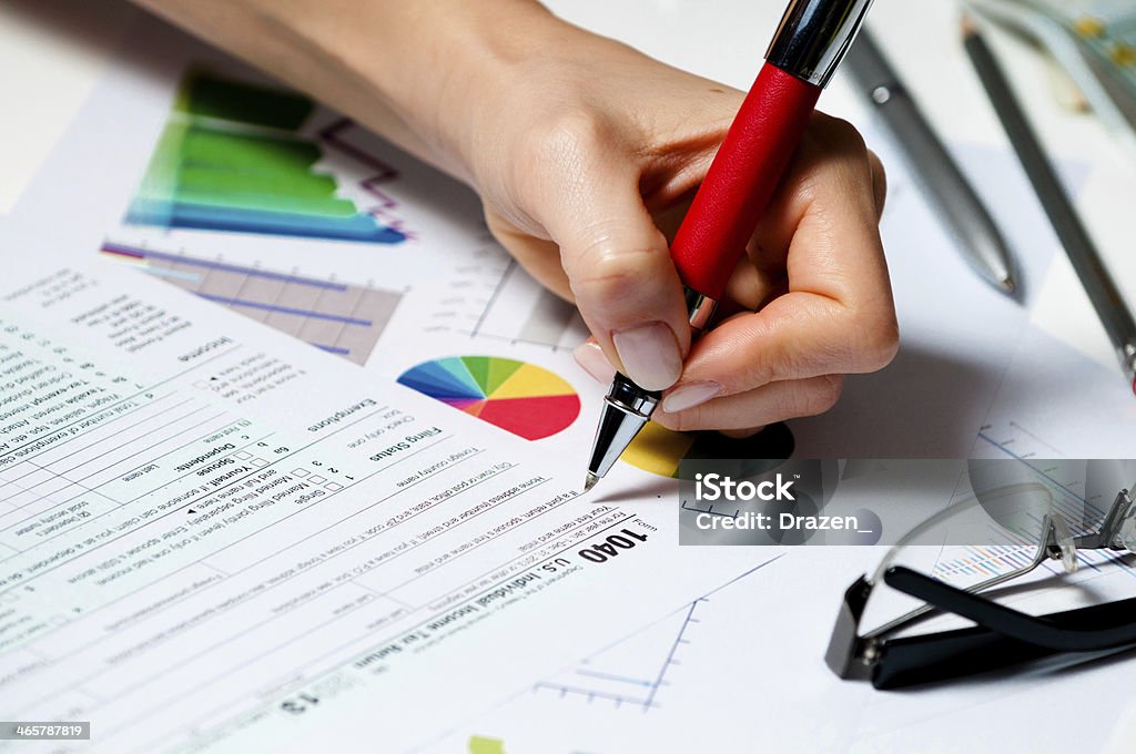 Businesswoman in office dealing with taxes finances and stock markets Business documents and tax forms in the close up photo 1040 Tax Form Stock Photo