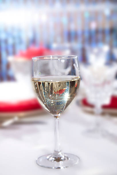 Beautiful elegant table setting with one white wine glass, crystal goblets and red napkins.  Table place setting.