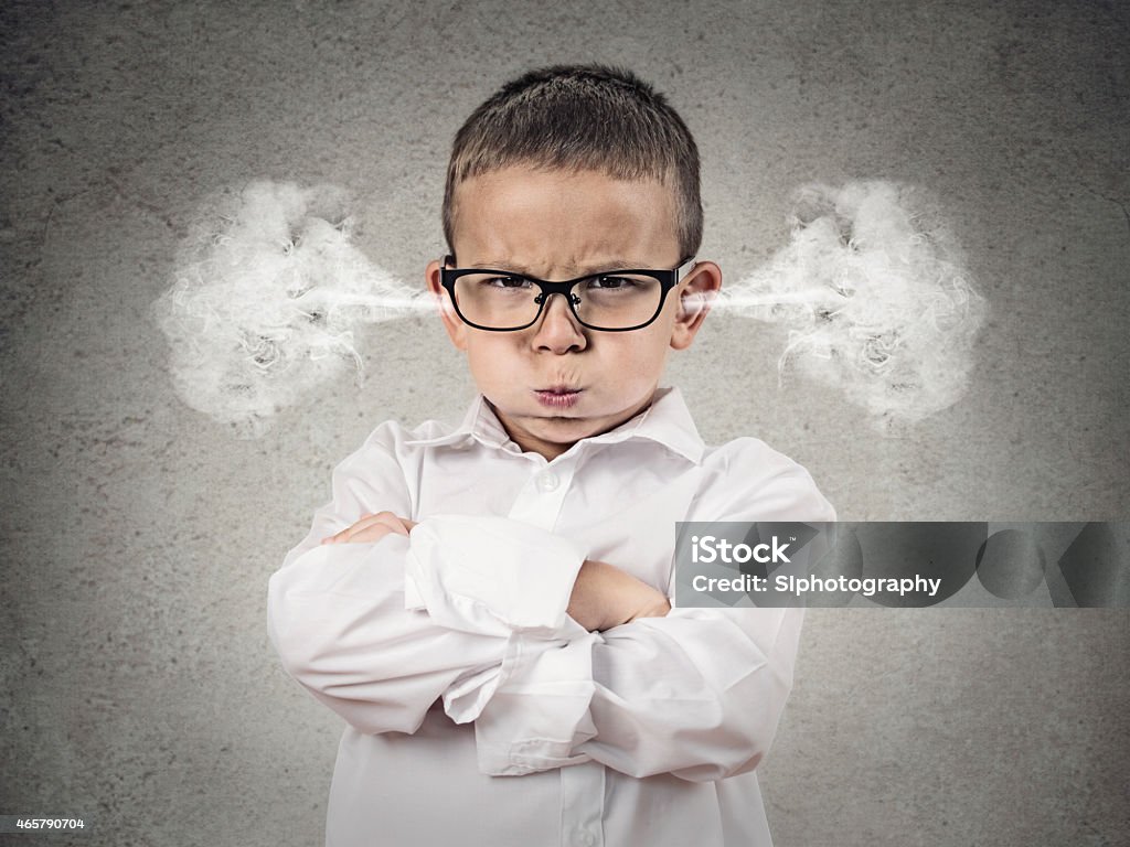 Angry upset boy, little man Closeup portrait Angry young Boy, Blowing Steam coming out of ears, about have Nervous atomic breakdown, isolated grey background. Negative human emotions, Facial Expression, feeling attitude reaction Child Stock Photo