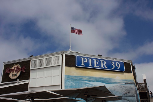 San Francisco, Usa - August 12, 2013: Roof architectural detail of famous Pier 39 in San Francisco, with Hard Rock cafè insigna and american flag  waving