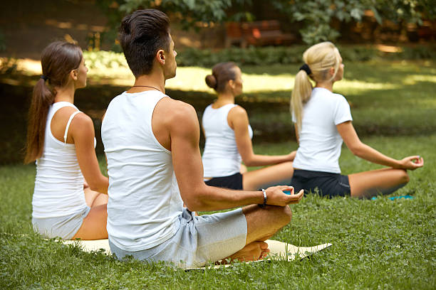 istock Yoga Class. Group of People Meditating At Summer Park 465805840