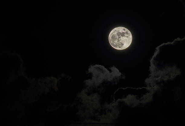 istock Full moon and  white clouds against a black sky 465821460