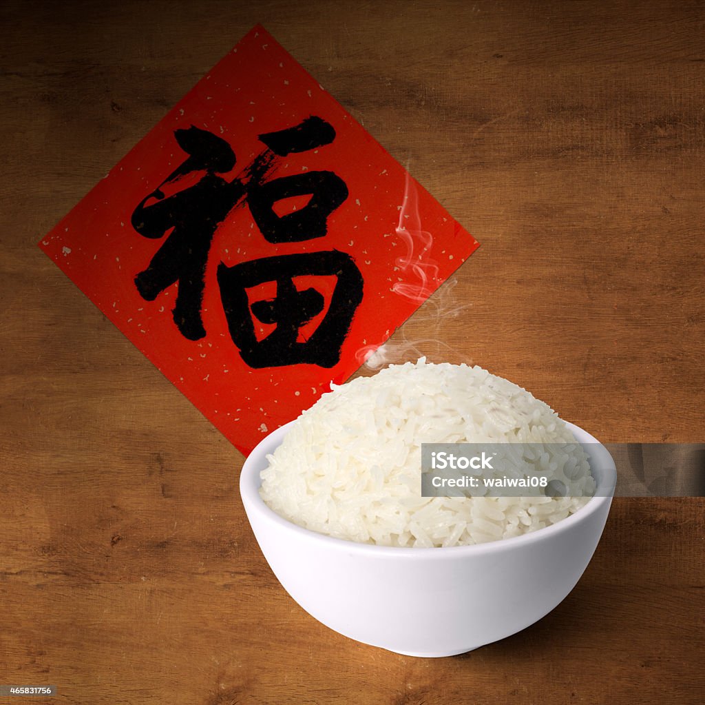 Bowl of cooked fragrance rice on wood with Chinese greetings 2015 Stock Photo