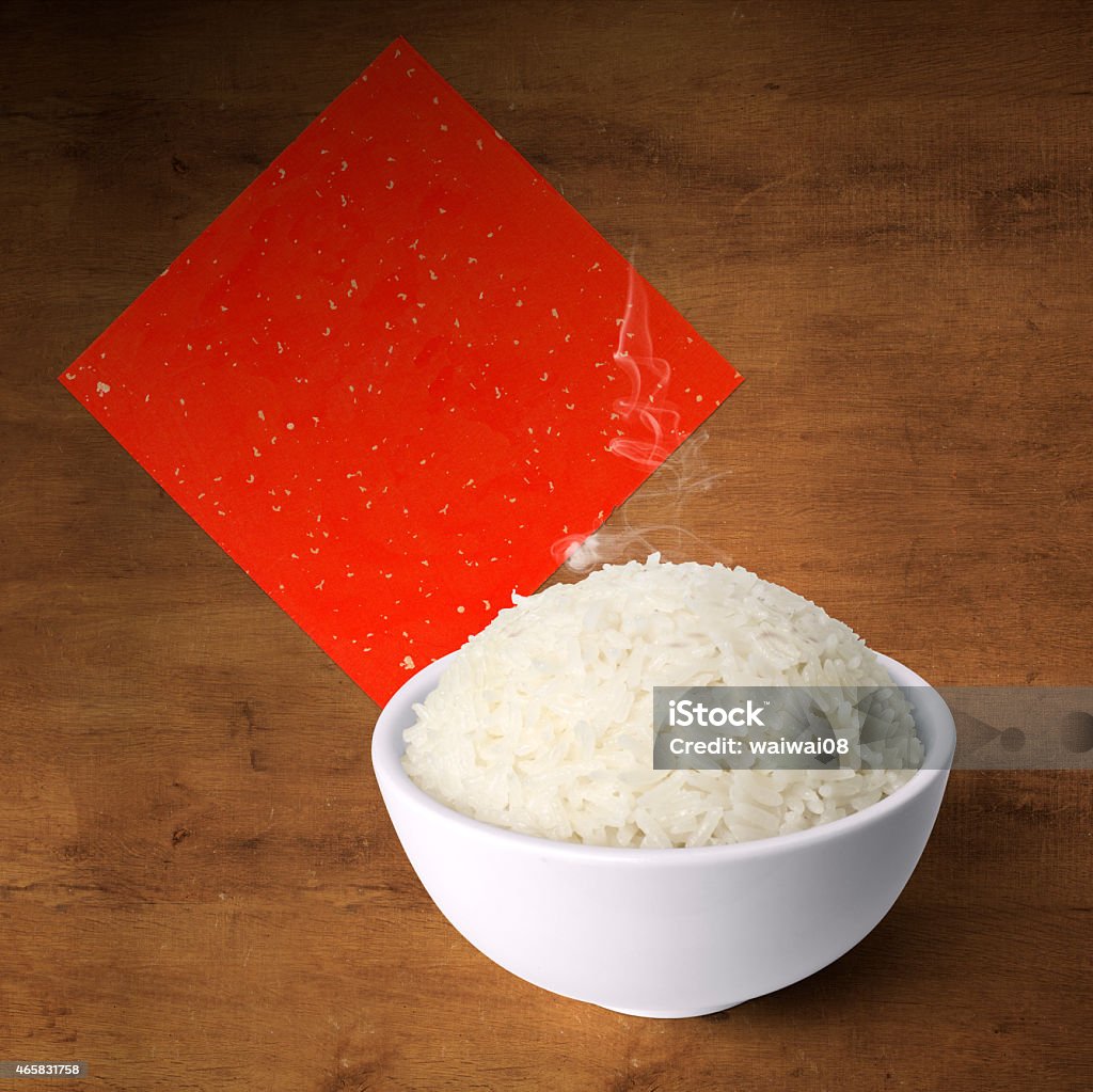 Bowl of cooked fragrance rice on wood with red paper Bowl of cooked fragrance rice on wood with Chinese red banner 2015 Stock Photo