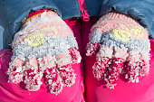 Lumps of frozen snow on woolen gloves