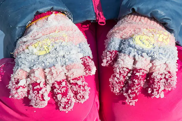 Photo of Lumps of frozen snow on woolen gloves