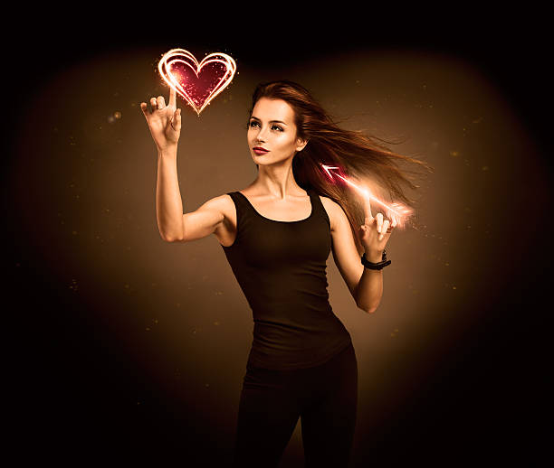 Woman Aiming to the Glowing Heart with an Arrow stock photo