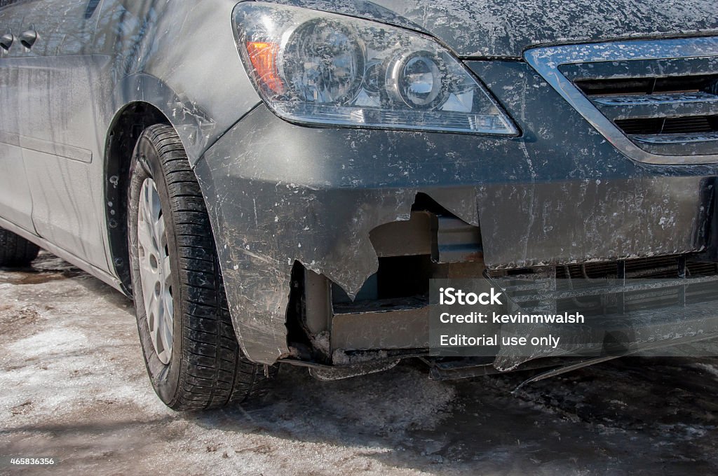 Winter Damage to Car Bumper Weymouth, MA, USA-March 7, 2007: A mini-van has a significant hole in its front end and bumper area after hitting a snow bank filled with ice chunks. 2015 Stock Photo